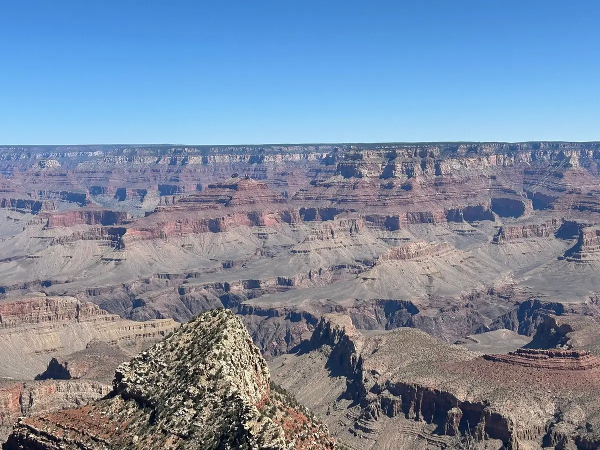 Ein klarer blauer Himmel über dem geschichteten South Rim des Grand Canyon